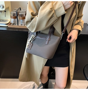 Detail of grey-brown leather tote bag with silk scarf and chocolate charm in cafe setting