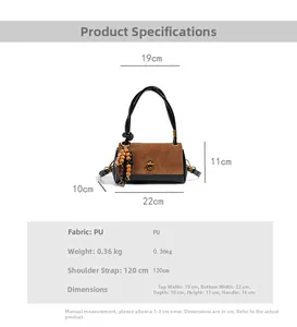Detail view of suede handbag showing size specifications and beaded tassel accessory