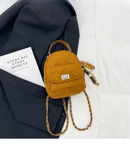 Détail d'un petit sac à dos matelassé en daim marron avec bandoulière chaîne