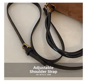 Detailed view of adjustable black leather shoulder strap with gold metal buckle