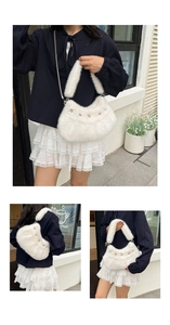 Gros plan du sac croissant en fausse fourrure blanche avec rivets étoiles et chaîne
