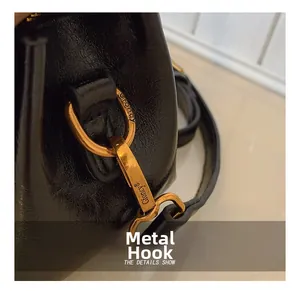 Detailed macro view of premium golden metal hook and hardware on black suede bag