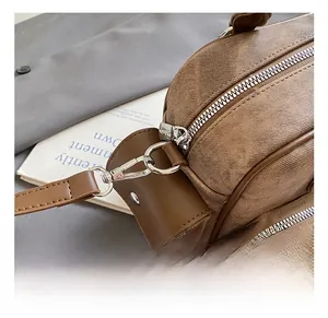 Detail of silver metal hook and crosshatch leather texture on brown bowling bag