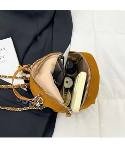 Détail de l'intérieur du sac à bandoulière en daim marron avec grande capacité de rangement