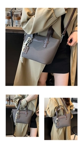 Detail of dark brown leather tote with woven charm and adjustable crossbody strap