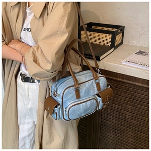 Detail of vintage bowling bag in light blue washed leather with brown leather handles