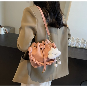 Détail du sac seau rose givré avec bordure tissée et breloque nuage en peluche