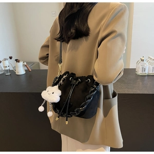 Détail du sac seau noir en cuir dépoli avec poignée tressée et charm nuage peluche