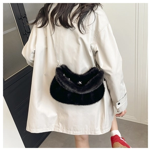 Détail du sac bandoulière en peluche noire avec étoile argentée et chaîne métallique