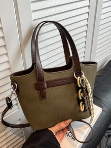 Army green canvas and brown leather tote bag with chain strap and tassel charm
