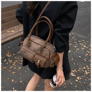 Detailed view of a retro brown bowling bag with multiple functional zipper pockets and straps