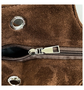 Macro detail of brown suede tote bag featuring high-quality silver metal zipper and eyelets