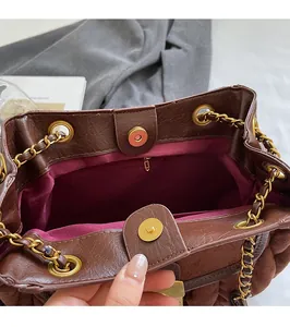 Detail of vintage brown bucket bag with gold magnetic clasp and magenta fabric lining
