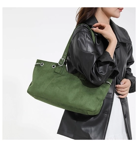 Detail of dark green suede tote bag showing adjustable metal buckle and retro texture