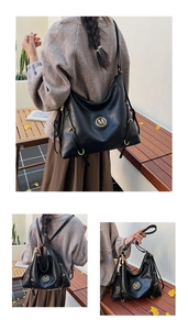 Detail of vintage black leather tote showing golden M logo and wooden bead tassel decor