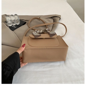 Detail of khaki pebbled leather handbag with printed silk scarf and adjustable strap