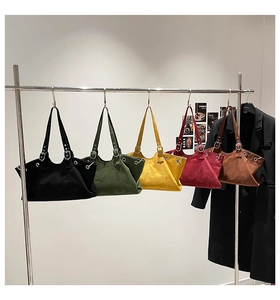Row of large canvas tote bags in five solid colors hanging on a silver metal rack
