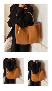 Detail of brown suede tote bag featuring colorful wooden bead charm and long shoulder straps