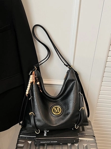 Vintage black leather hobo tote bag with gold M logo and decorative beaded charms