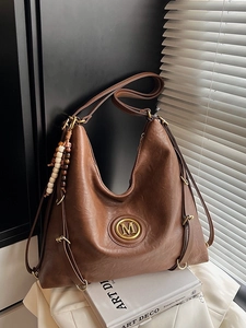 Vintage brown leather tote bag with M logo, wood bead charm and adjustable strap