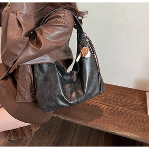Detail of vintage gray faux leather tote bag with woven cord and cute animal charm