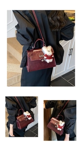 Detail view of burgundy glossy trapezoid handbag with a plush bear charm and metal lock