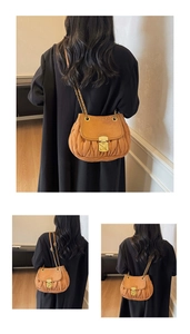 Detail of vintage brown pleated leather crossbody bag with gold chain and clasp closure