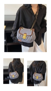 Detail of vintage saddle bag with pleated fabric and brown leather trim on a model