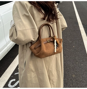 Brown suede handbag detail with bohemian beaded tassel and brown leather handle