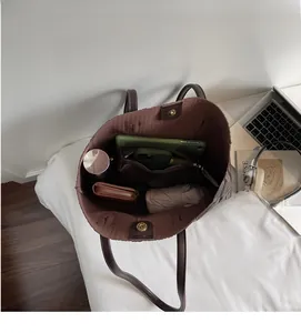 Vue intérieure montrant la grande capacité du sac cabas tressé avec vos essentiels