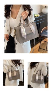 Macro shot of grey lychee textured leather tote with silk scarf and gold hardware