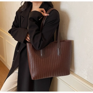 Détail du grand sac cabas tissé marron café montrant la texture du cuir tressé
