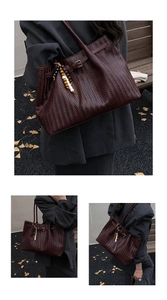 Detail of woven tote bag in dark reddish brown with retro beaded pendant and buckle
