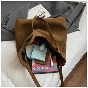 Macro view of large capacity dark brown suede tote bag showing interior storage for iPad