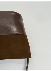 Primo piano della borsa marrone scuro con contrasto tra pelle liscia e pelle scamosciata