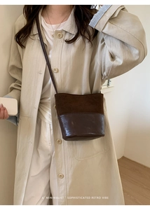 Détail du sac seau marron foncé avec mélange de textures daim et cuir lisse poli