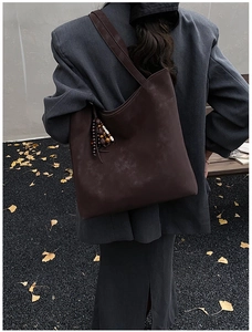 Detail of dark brown faux suede tote bag with ethnic beaded tassel and large capacity
