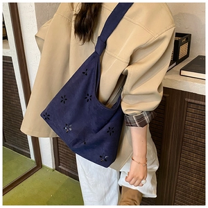 Close-up of navy blue hollow floral tote bag with a stylish knotted shoulder strap