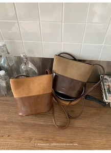 Détails de sacs seaux vintage en daim et cuir lisse sur un bureau en bois rustique