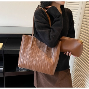 Détail d'un cabas tressé marron avec texture en similicuir et pochette assortie
