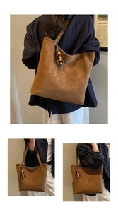 Detail of vintage brown tote bag with beaded tassel and distressed leather texture