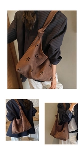 Close-up of brown suede tote bag featuring laser-cut floral patterns and unique knot detail