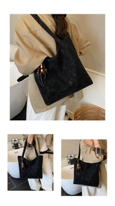 Detail of black suede tote bag with wooden bead tassel and spacious vintage design