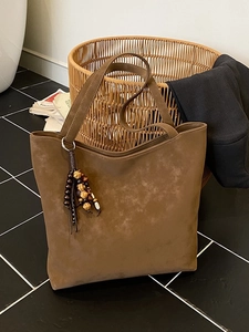 Brown faux suede large tote bag with vintage ethnic tassel in a home lifestyle setting