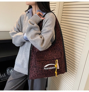 Grande borsa tote leopardata con tasca frontale e nappe colorate indossata da modella