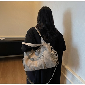 Vue détaillée d'un grand sac vintage gris à texture lavée et double bandoulière