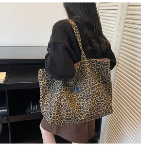 Detailed view of leopard print canvas tote bag with side pocket shown on shoulder