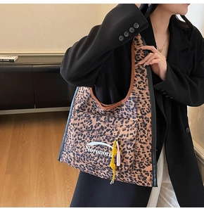 Dettaglio della borsa tote grande con stampa leopardata, tasca esterna e ciondoli