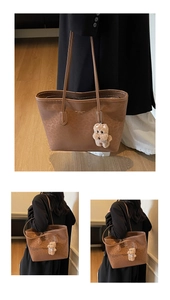 Detail of brown animal print tote bag featuring gold logo and cute plush puppy charm