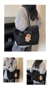 Close-up of black leopard pattern tote bag with a plush bear pendant accessory